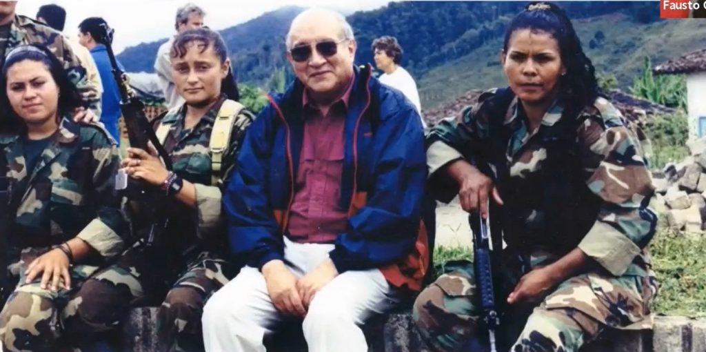 Embajador posando con mujeres militares en las montañas al hablar de dinámicas internacionales