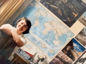 Emabajadora joven sentada enfrente de mapa del mundo