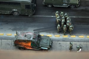 Vista aérea de auto militares y soldados.