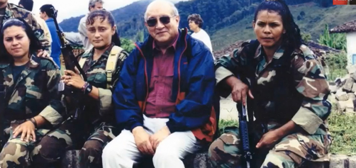 Embajador posando con mujeres militares en las montañas al hablar de dinámicas internacionales